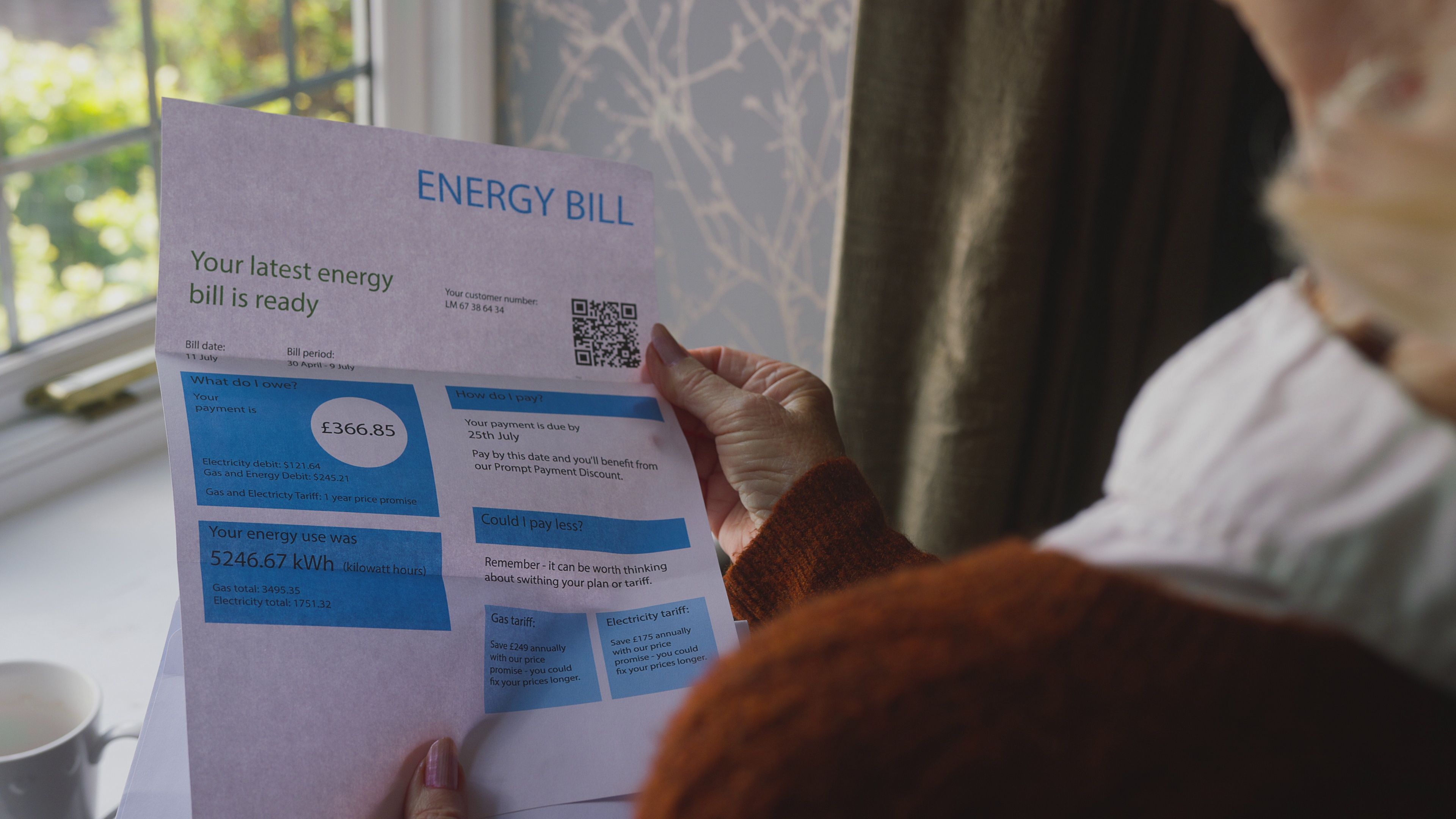Person reviewing energy bill showing high costs and payment details, representing the need for energy-efficient upgrades